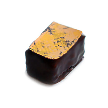 Hand dipped praline with a pressed abstract yellow pattern on top